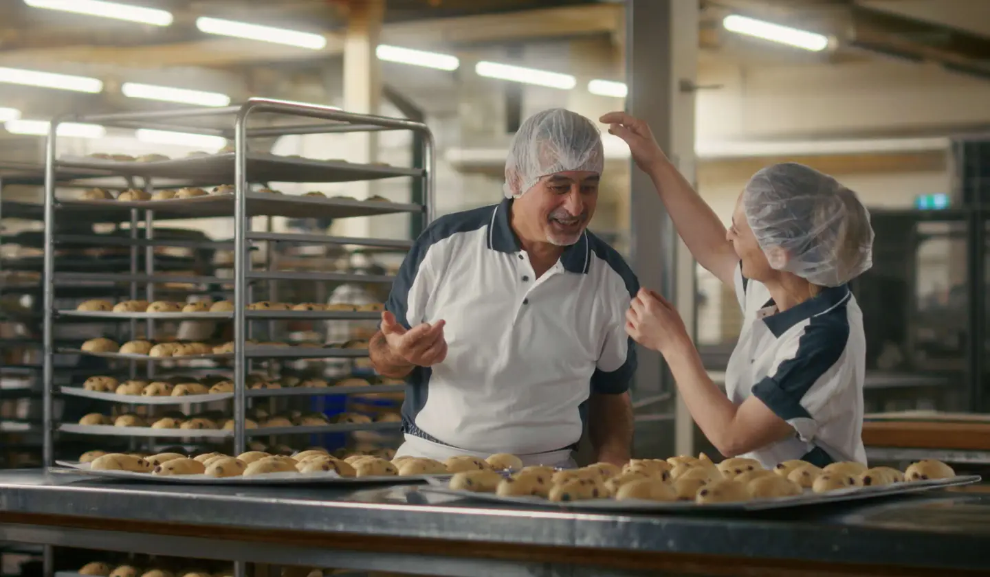Zwei Bäcker lachen gemeinsam in der Backstube.